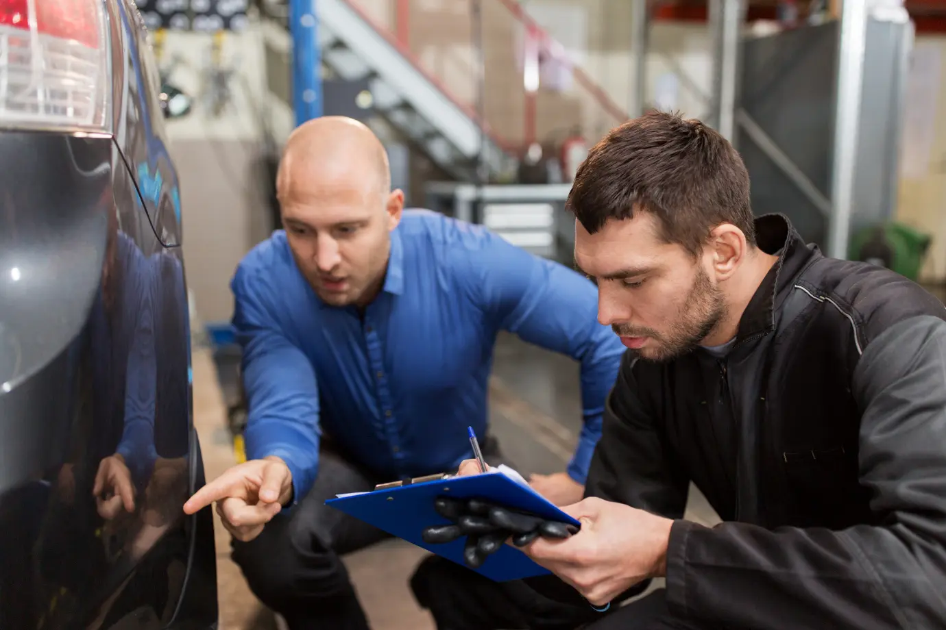 Mechanic struggling with paperwork while calculating repair costs manually