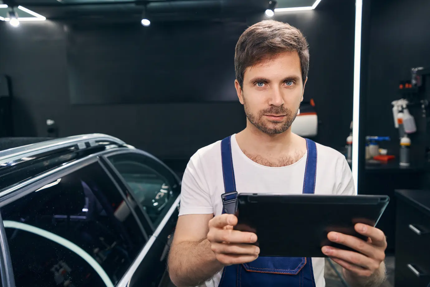 Technician analyzing spare parts catalog data on a laptop in a service workshop