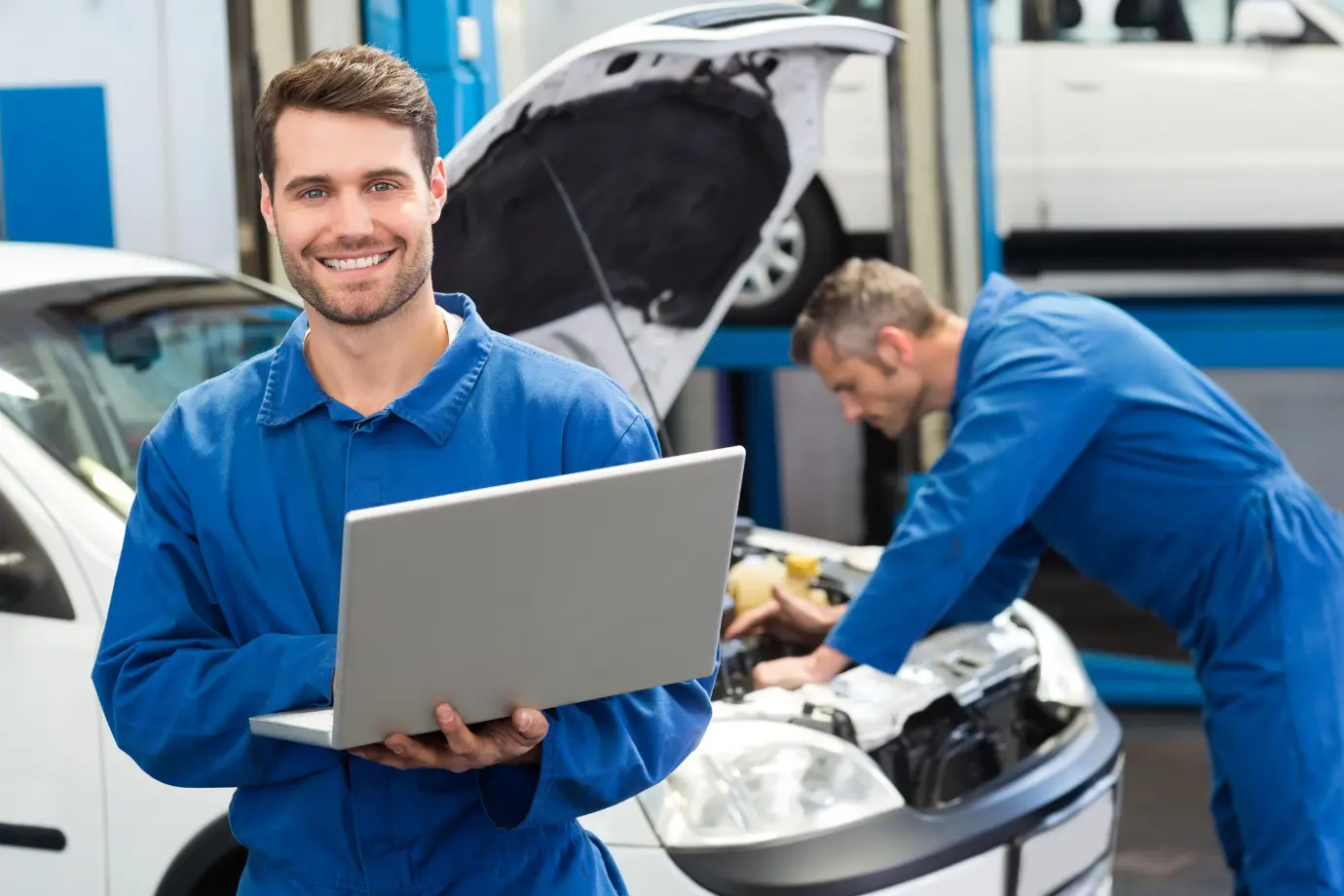 Aftermarket technicians analyzing data on a laptop to improve operational decisions.