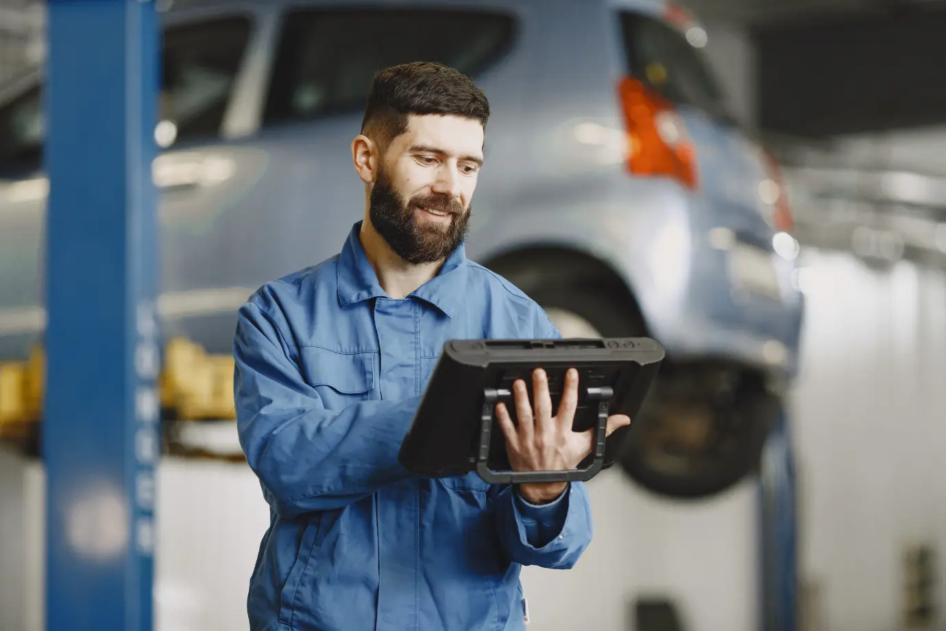 echnician accessing mobile digital service manual on tablet in workshop