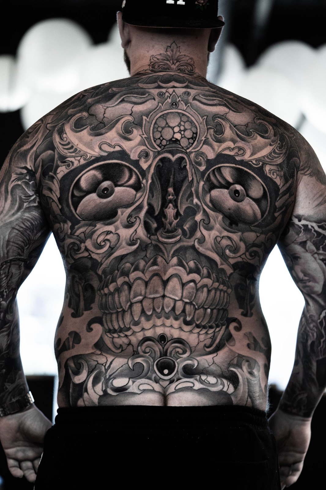 tibetan skull back tattoo with roses in black and grey