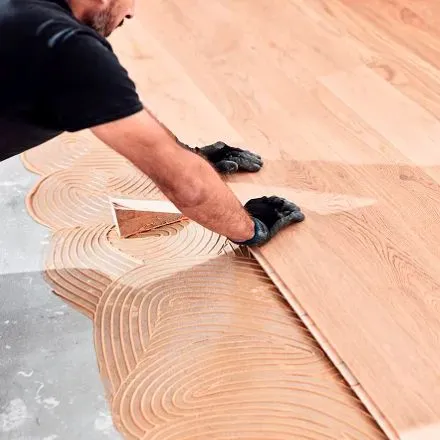 Contractor installing wood flooring.