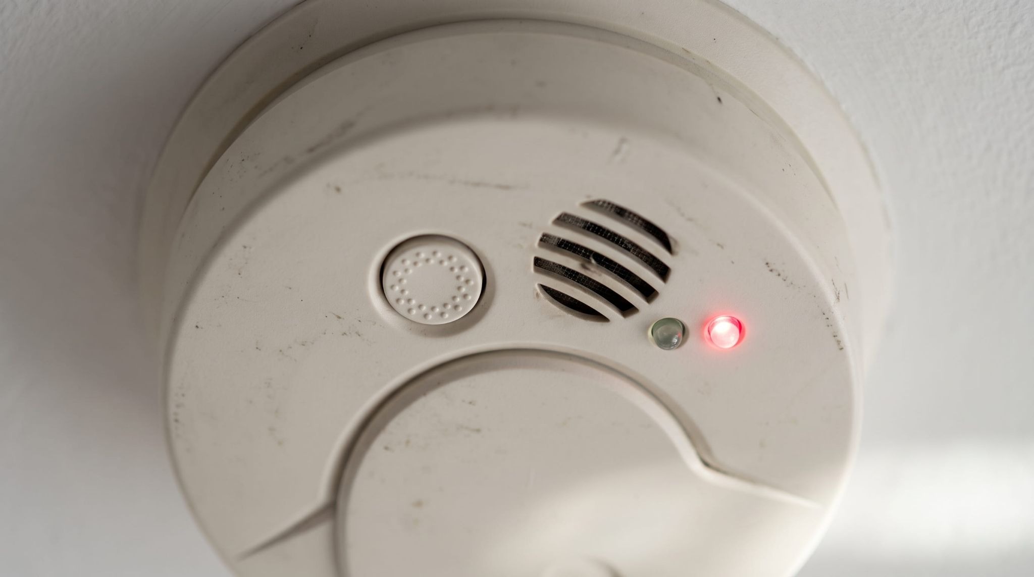 Smoke detector status lights and hush button showing a red low battery flash