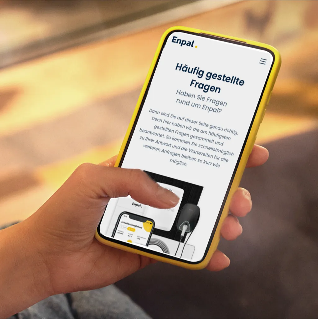 Hand mit Handy und der Enpal FAQ-Seite