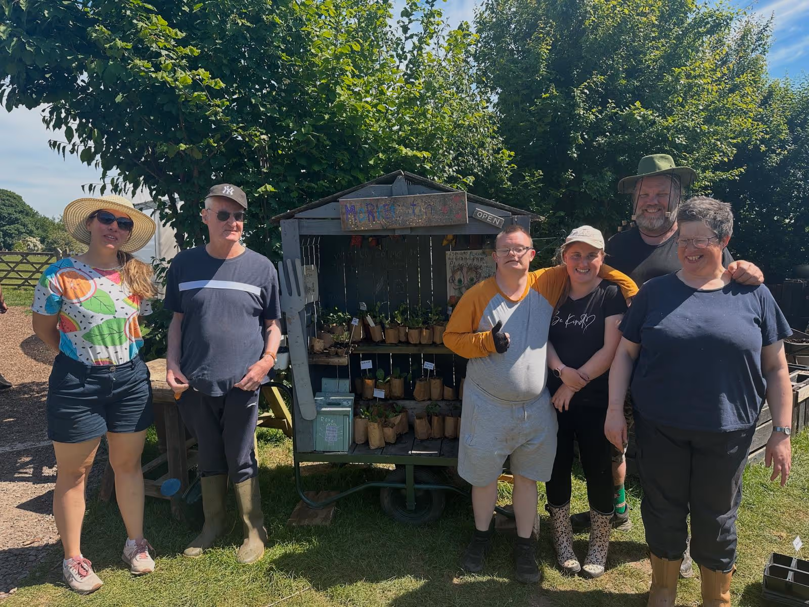 Care farm attendees in the Community Garden with plant sale stand