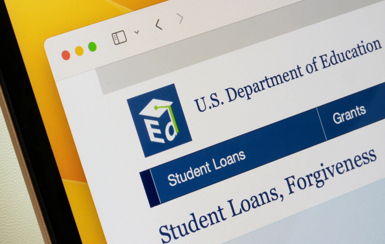 Close-up of a computer screen displaying the U.S. Department of Education website with sections on student loans and grants.