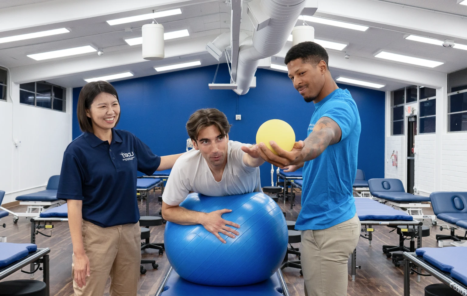 SCU Doctor of Physical Therapy students practice a guided rehabilitation exercise with a faculty member in a clinical skills lab.