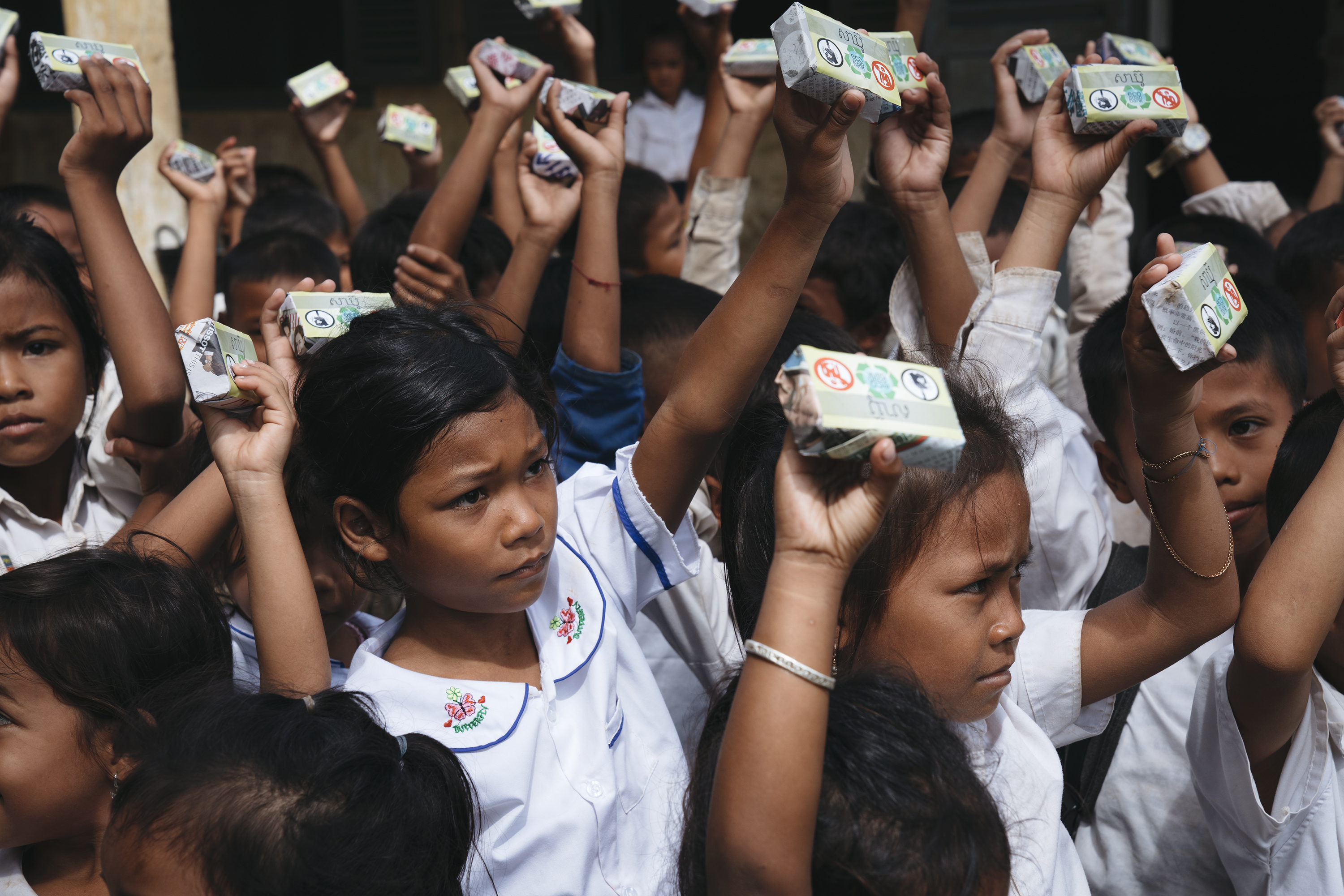 Schoolchildren raising boxes of Eco-Soap Bank recycled soap above their heads