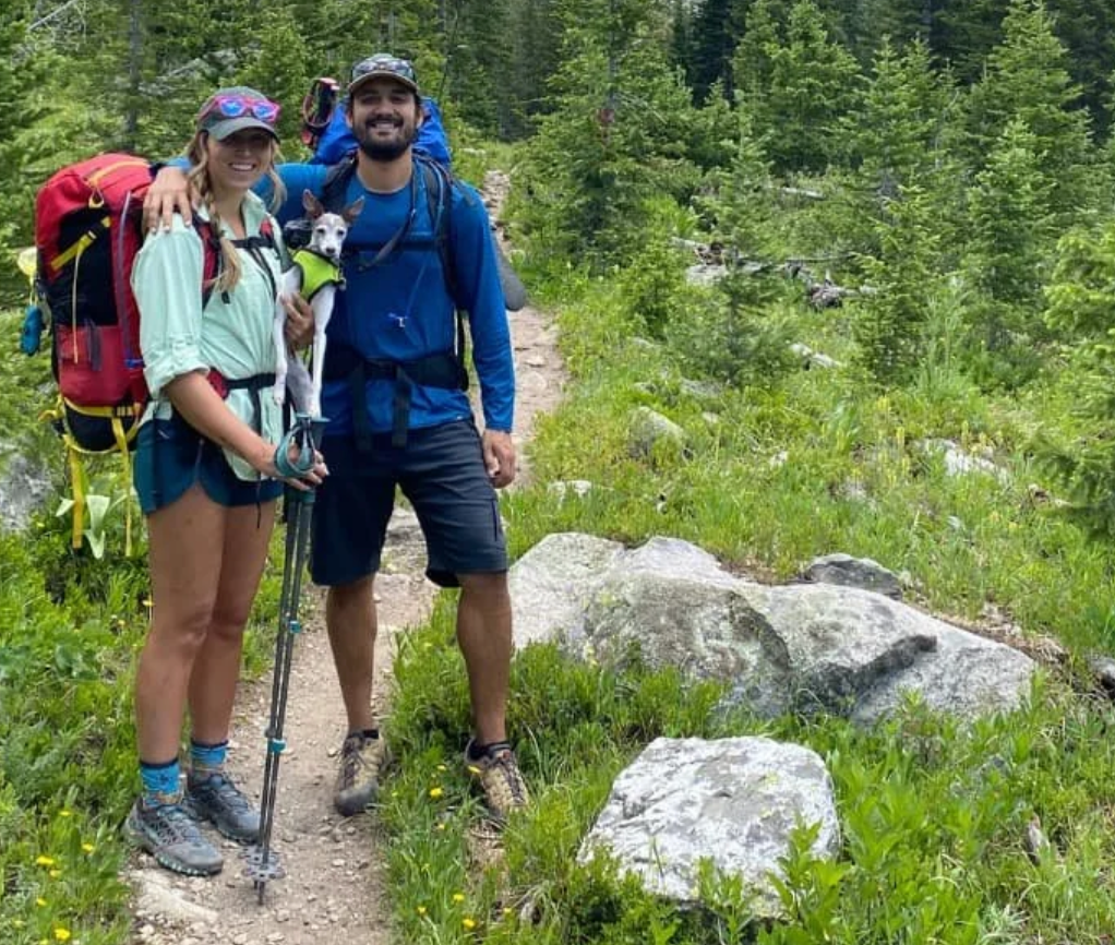 newlyweds on a hike with their dog