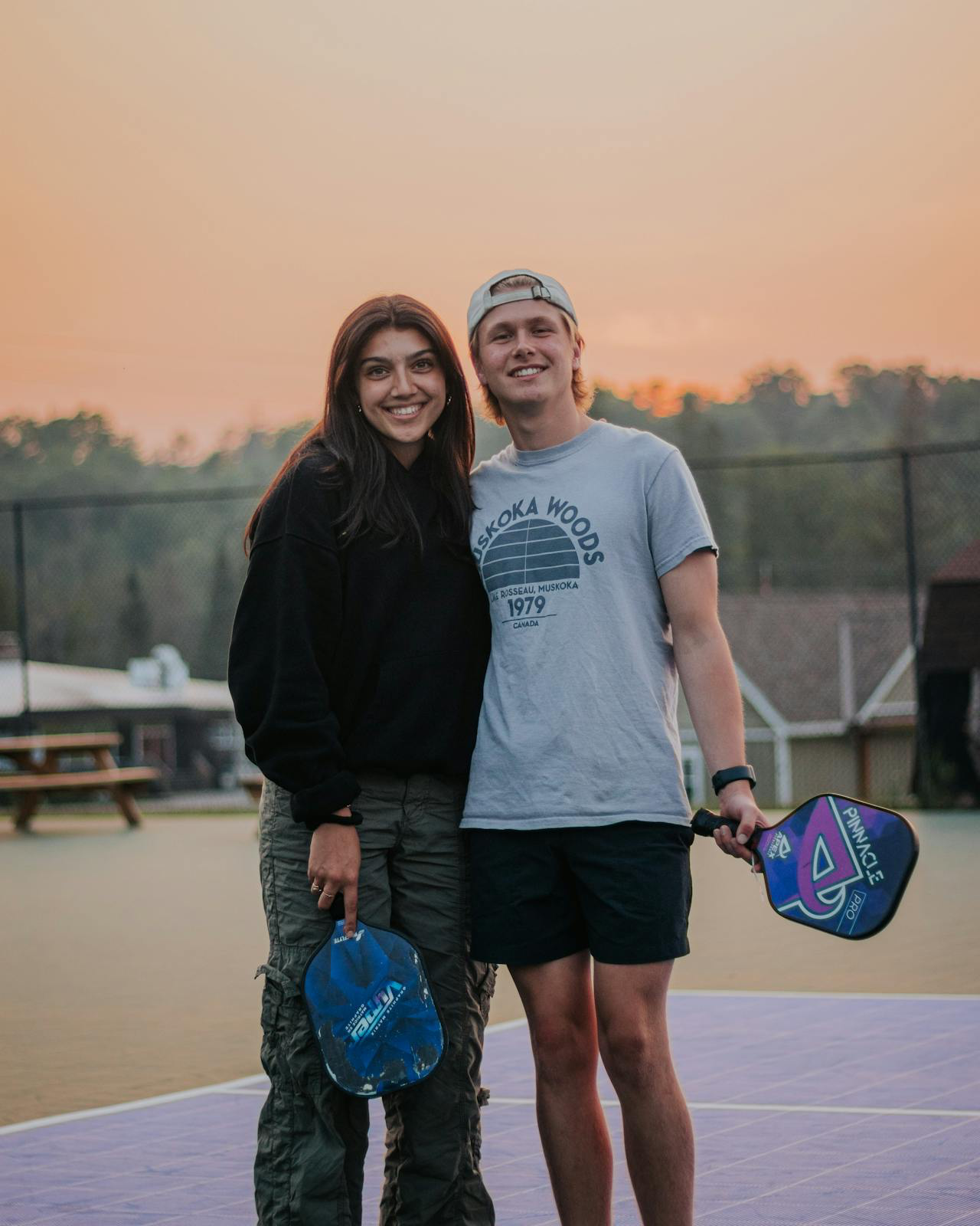 young couple poses happily on a pickleball court