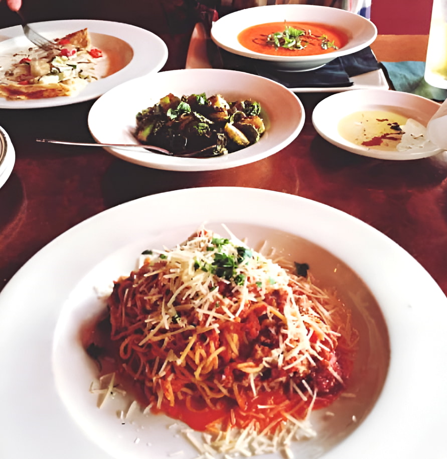 A table filled with various plates of food, showcasing a colorful assortment of dishes ready for serving. 