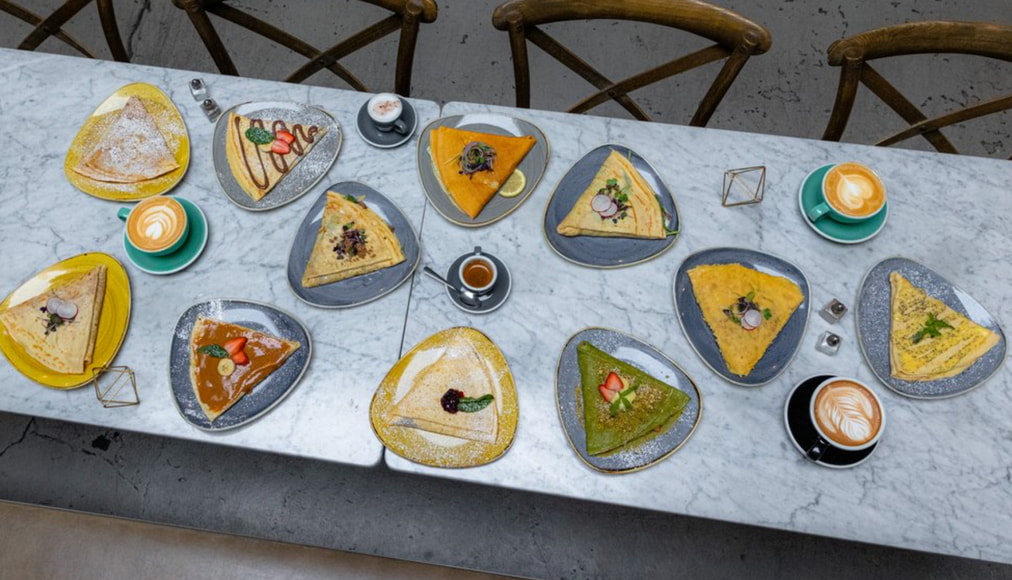 A table filled with various plates of food, showcasing a colorful assortment of dishes ready for serving.