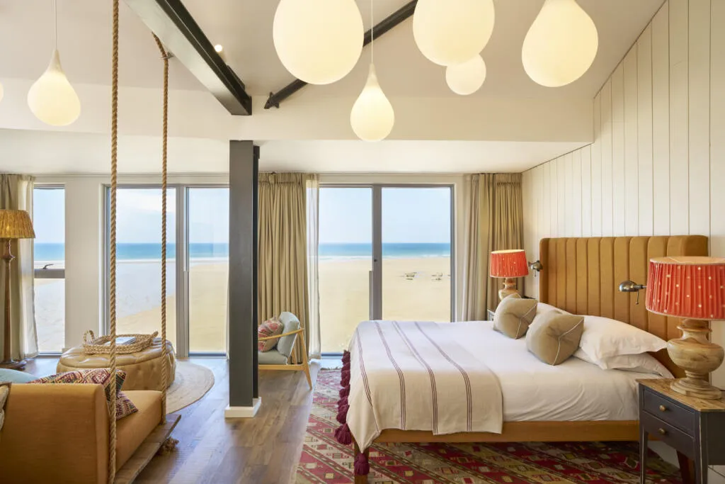 A bright sea-view bedroom at Watergate Bay Hotel looking out over the beach