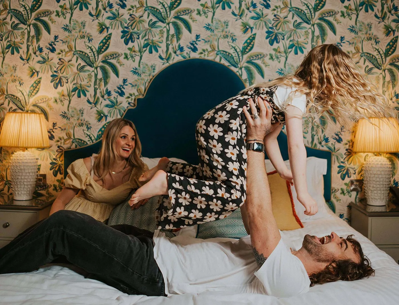 A family playing together on a bed in a characterful room at The Headland Hotel