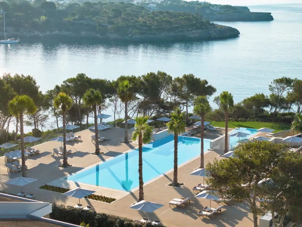 Pools and pine trees above the sea at Ikos Porto Petro in Mallorca