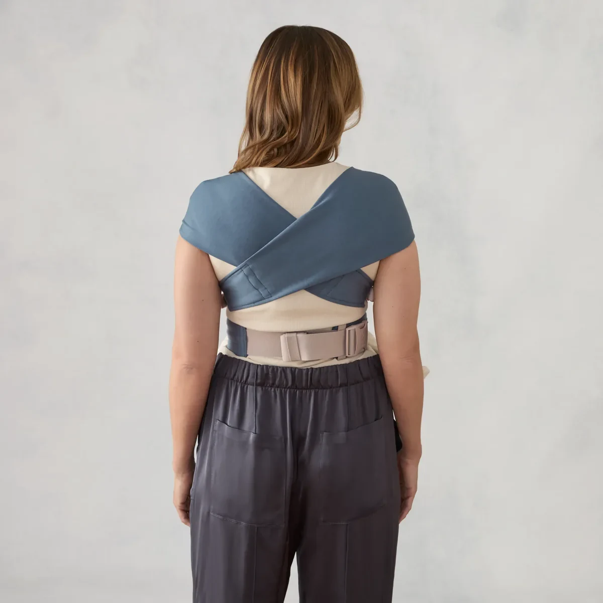 The Ergobaby Embrace carrier seen from behind, showing the cross-back straps