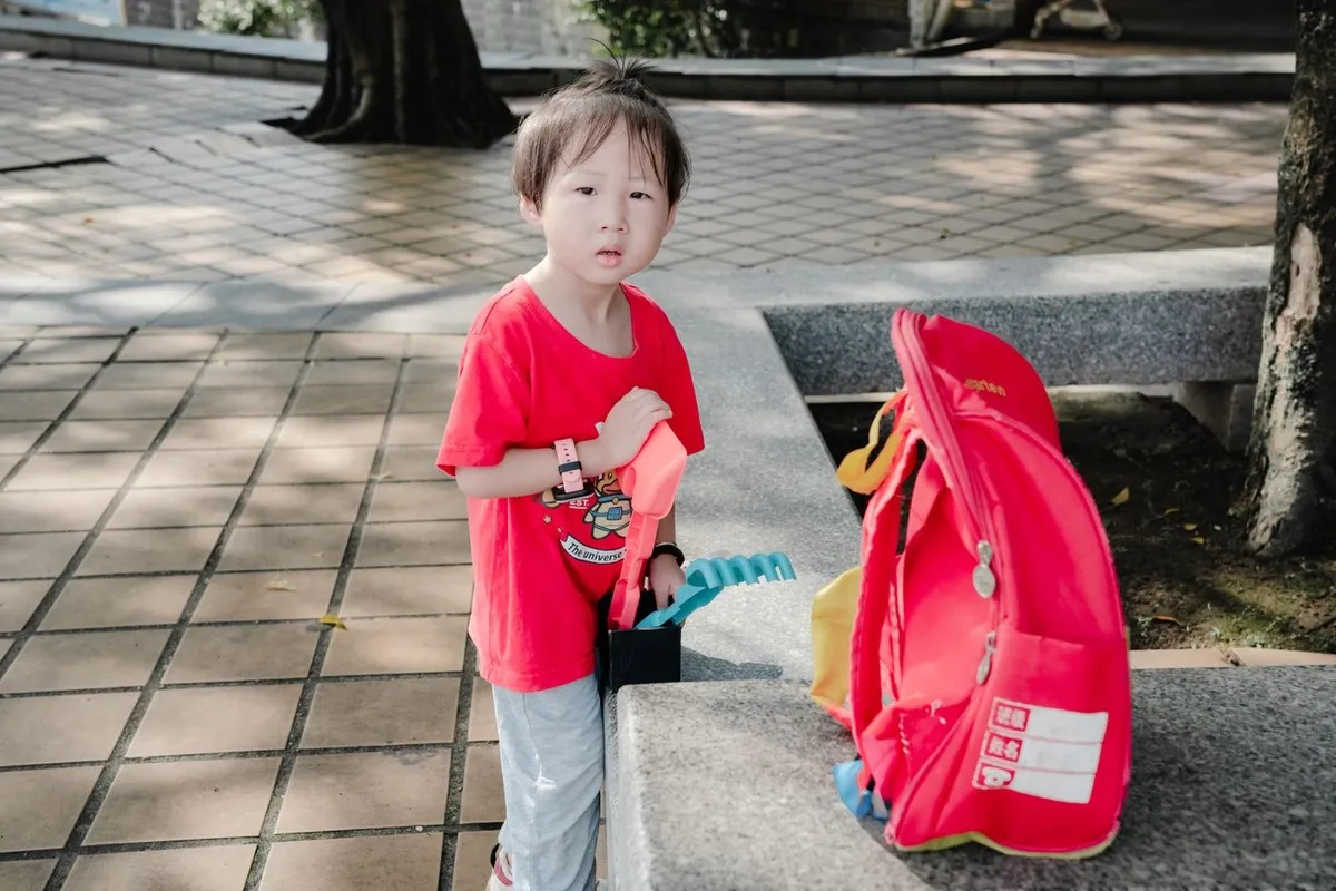 A little boy with a red school backpack
