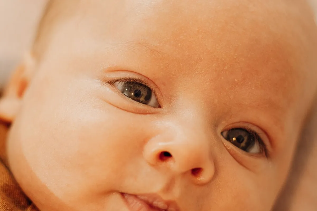 A close-up of a newborn baby looking at the camera