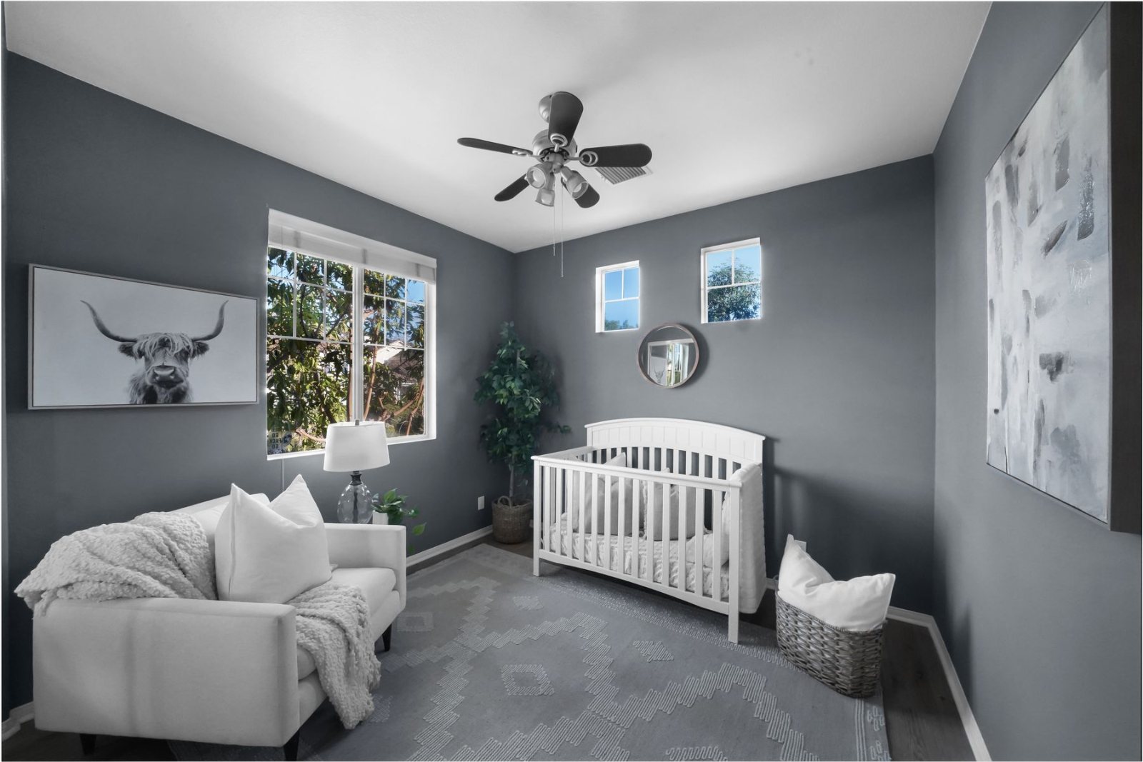 Calm grey nursery with a white cot and armchair