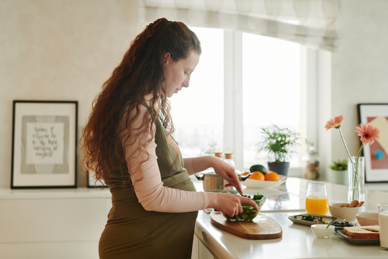 Pregnant woman preparing a healthy meal in her kitchen