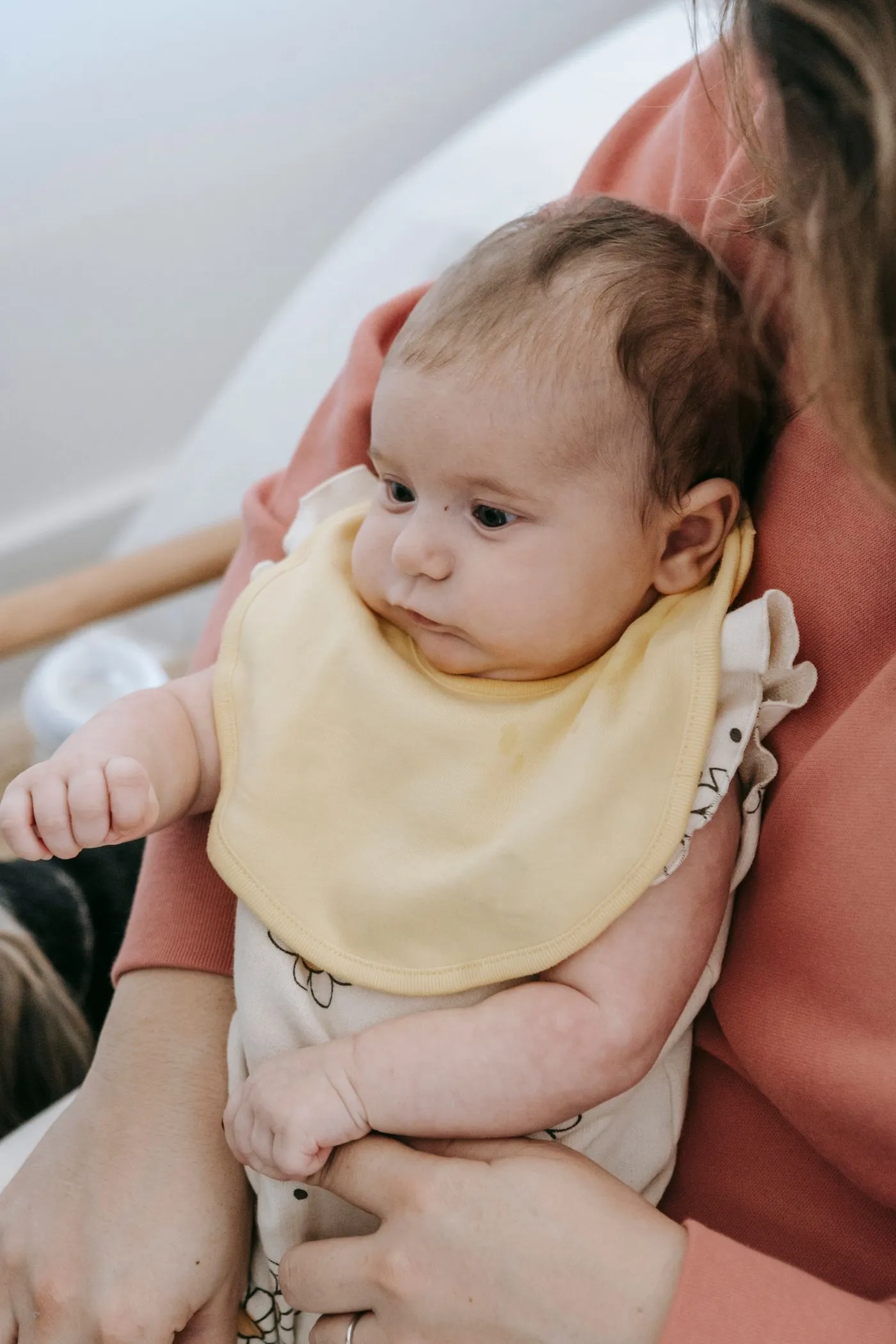 A mother at home holding her baby close against her chest
