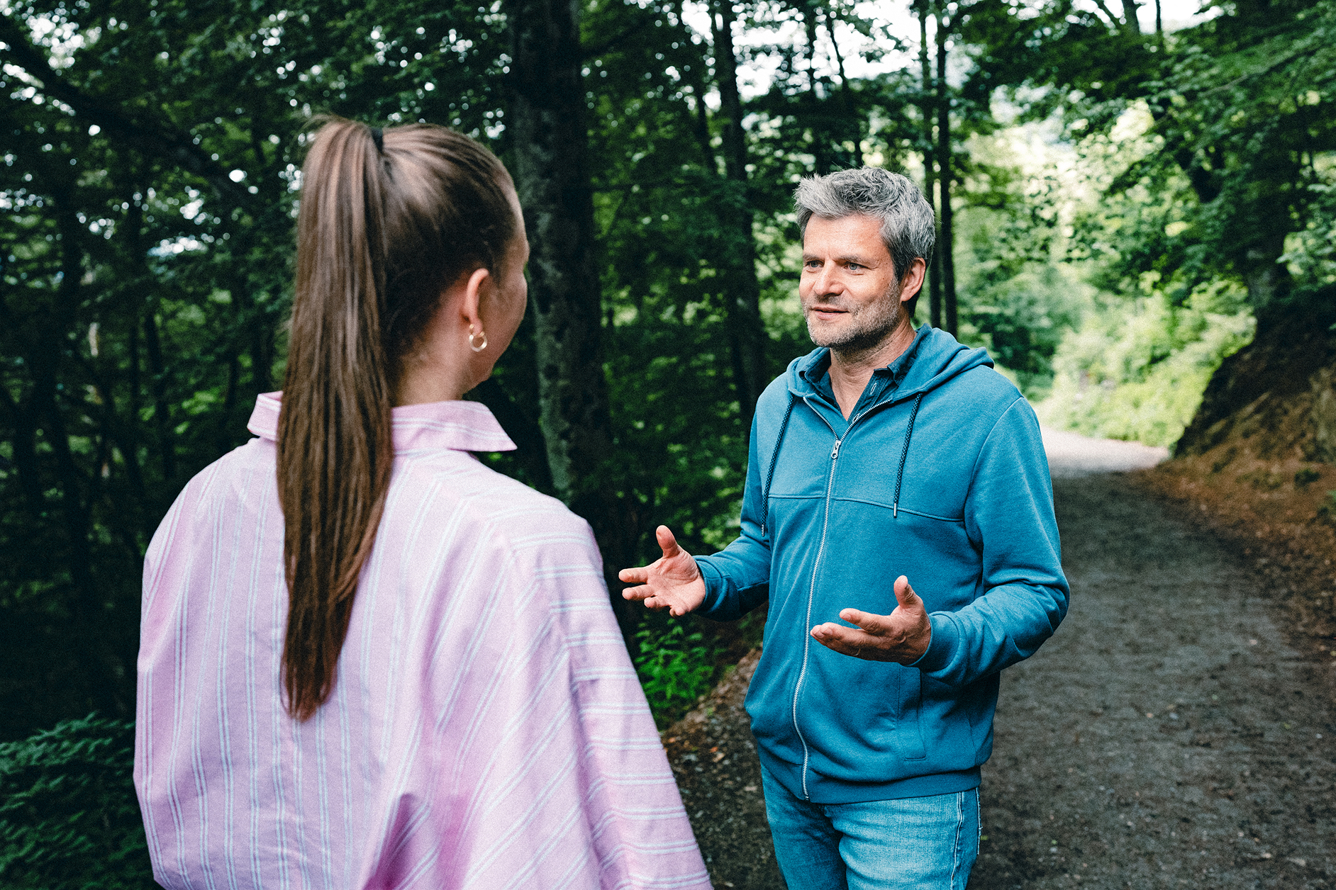 Raik Mickler, Konzerndatenschutzbeauftragter der Haufe Group, im Gespräch mit einer Frau auf einem Waldweg.