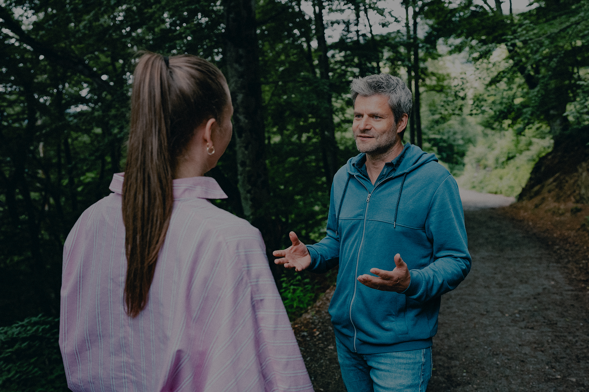 Raik Mickler, Konzerndatenschutzbeauftragter der Haufe Group, im Gespräch mit einer Frau auf einem Waldweg.