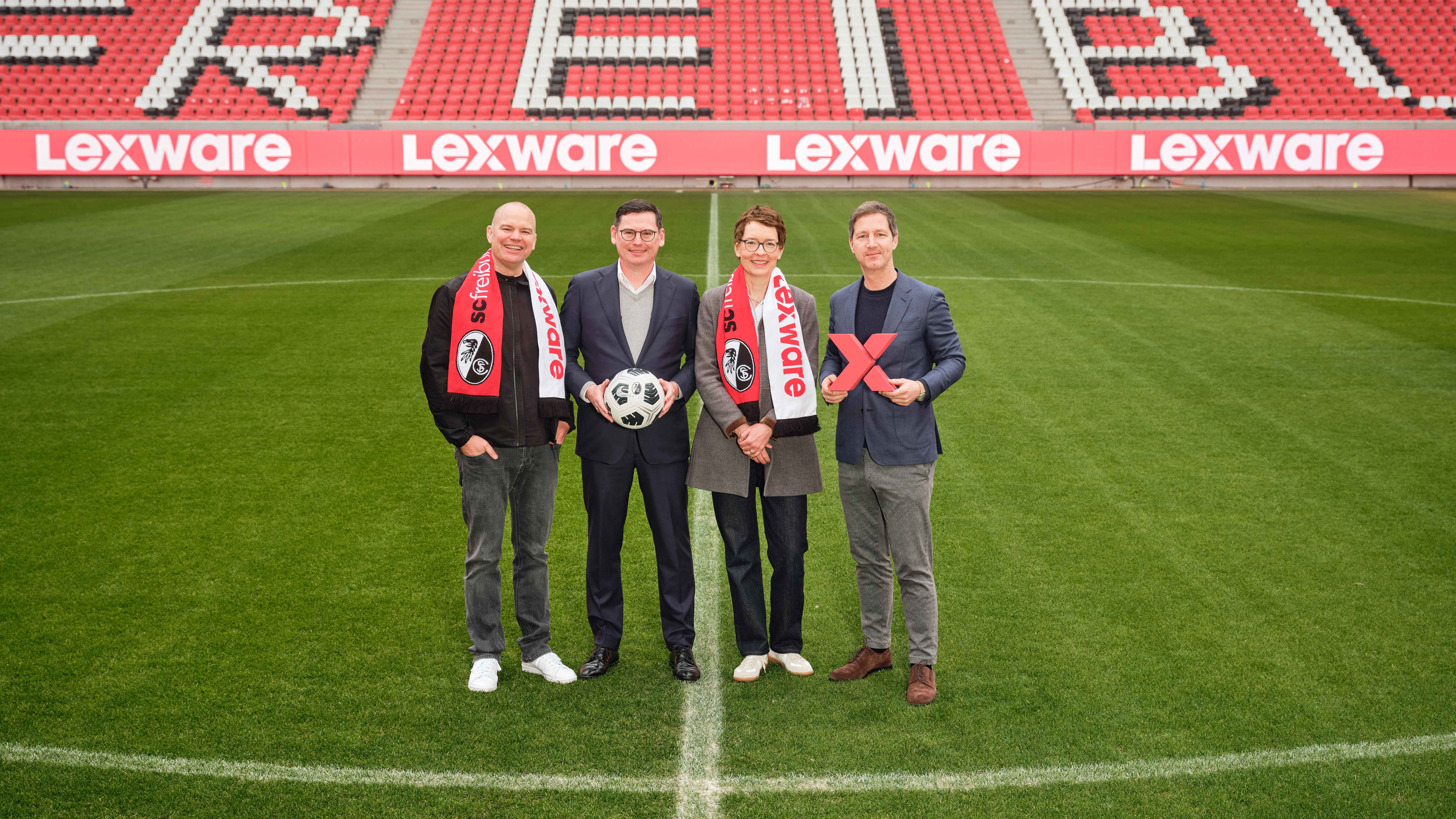 Christian Steiger, Oliver Leki, Birte Hackenjos und Jochen Saier im Europa-Park Stadion mit einer Lexware-LED-Bande im Hintergrund