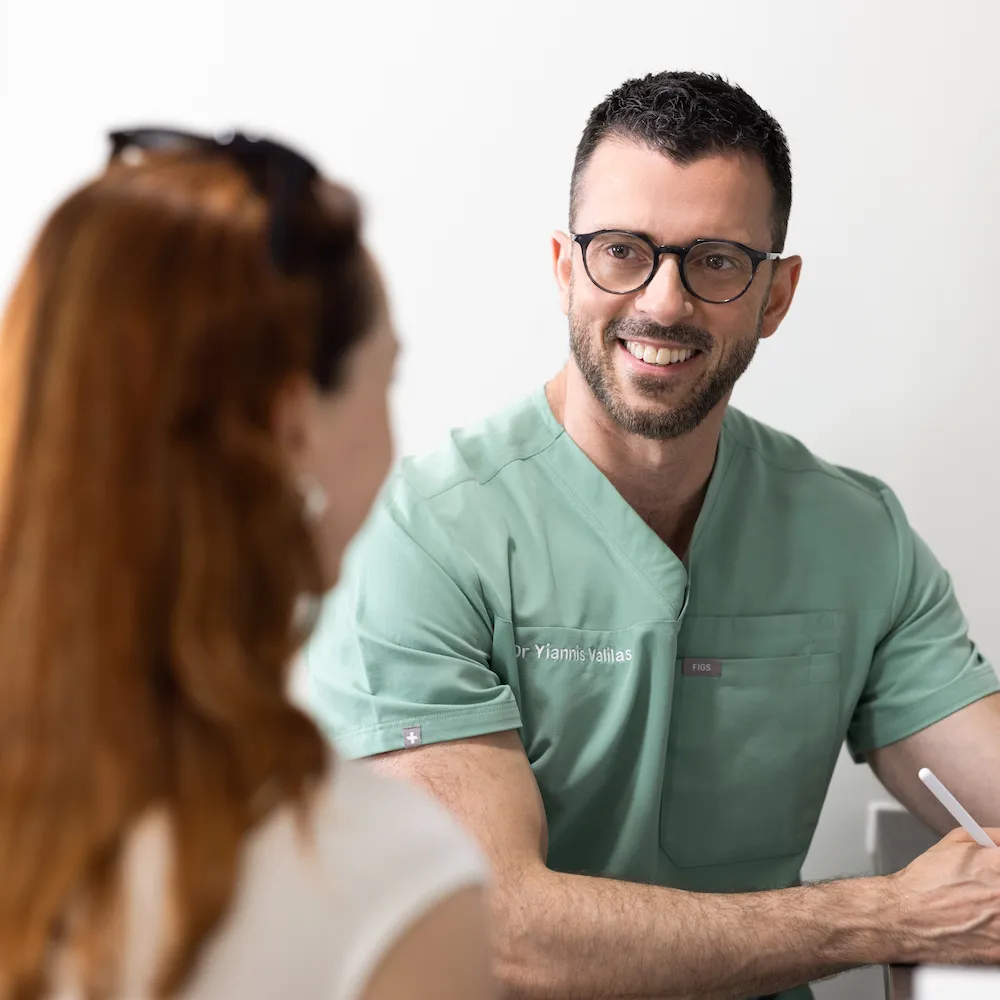 Anti Wrinkle specialist with glasses talking to a patient