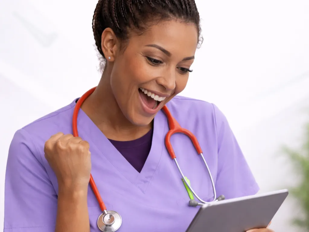 Nursing student using a smartphone to take a mobile-friendly NCLEX-RN practice exam at home.
