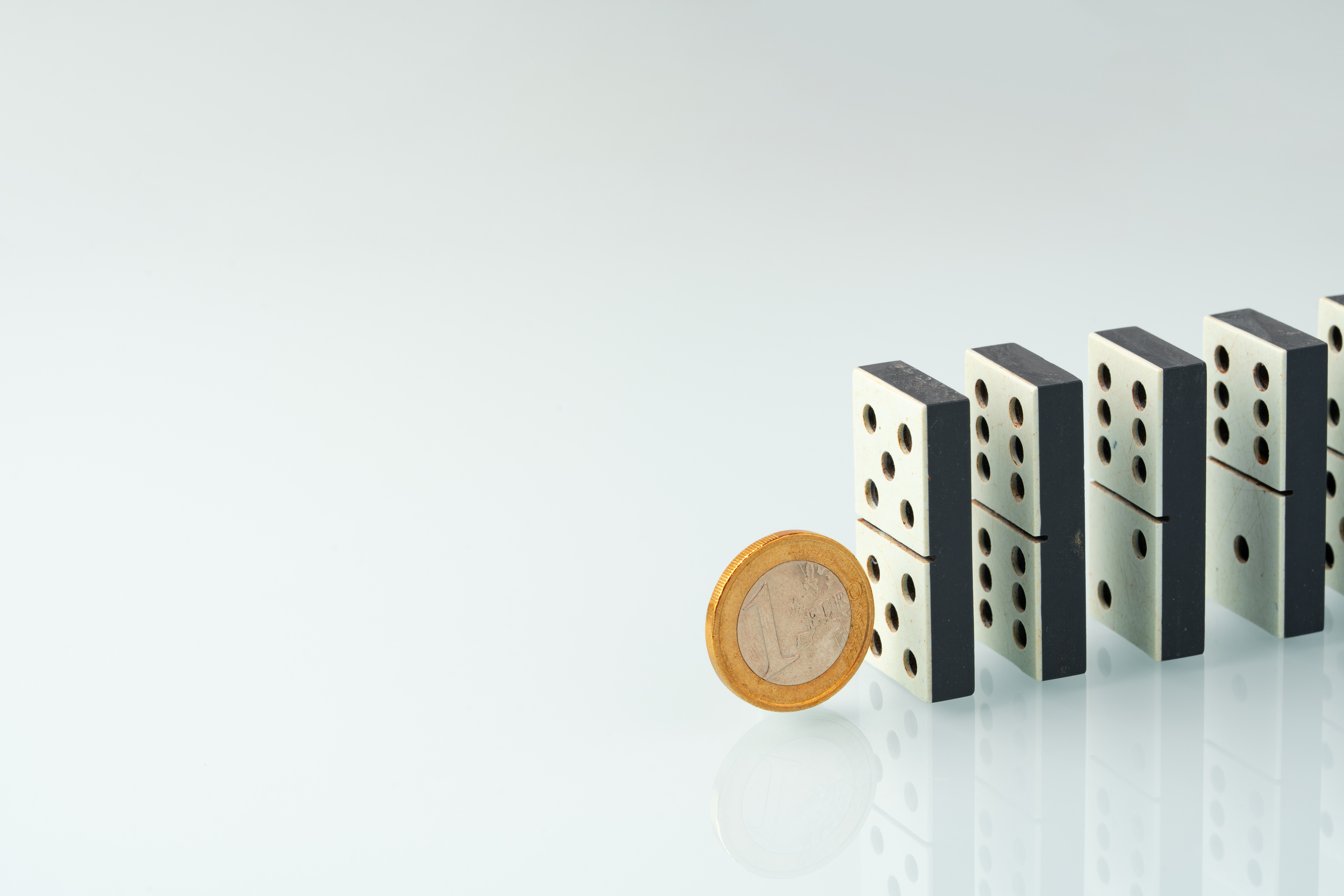 Domino tiles and coins representing cascading financial risk from unproven agentic AI spending