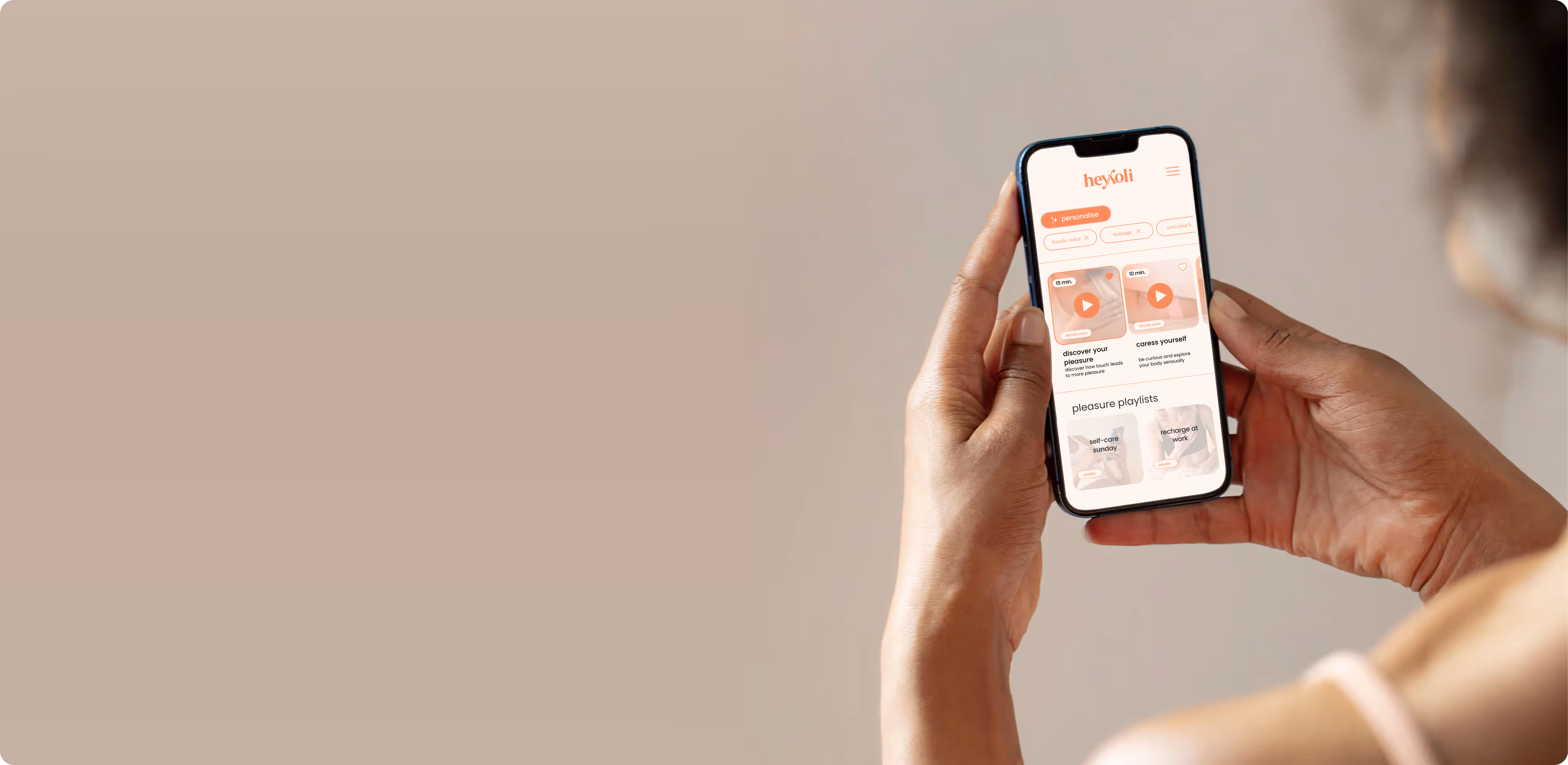 woman holds phone with app preview guided audios heyyoli