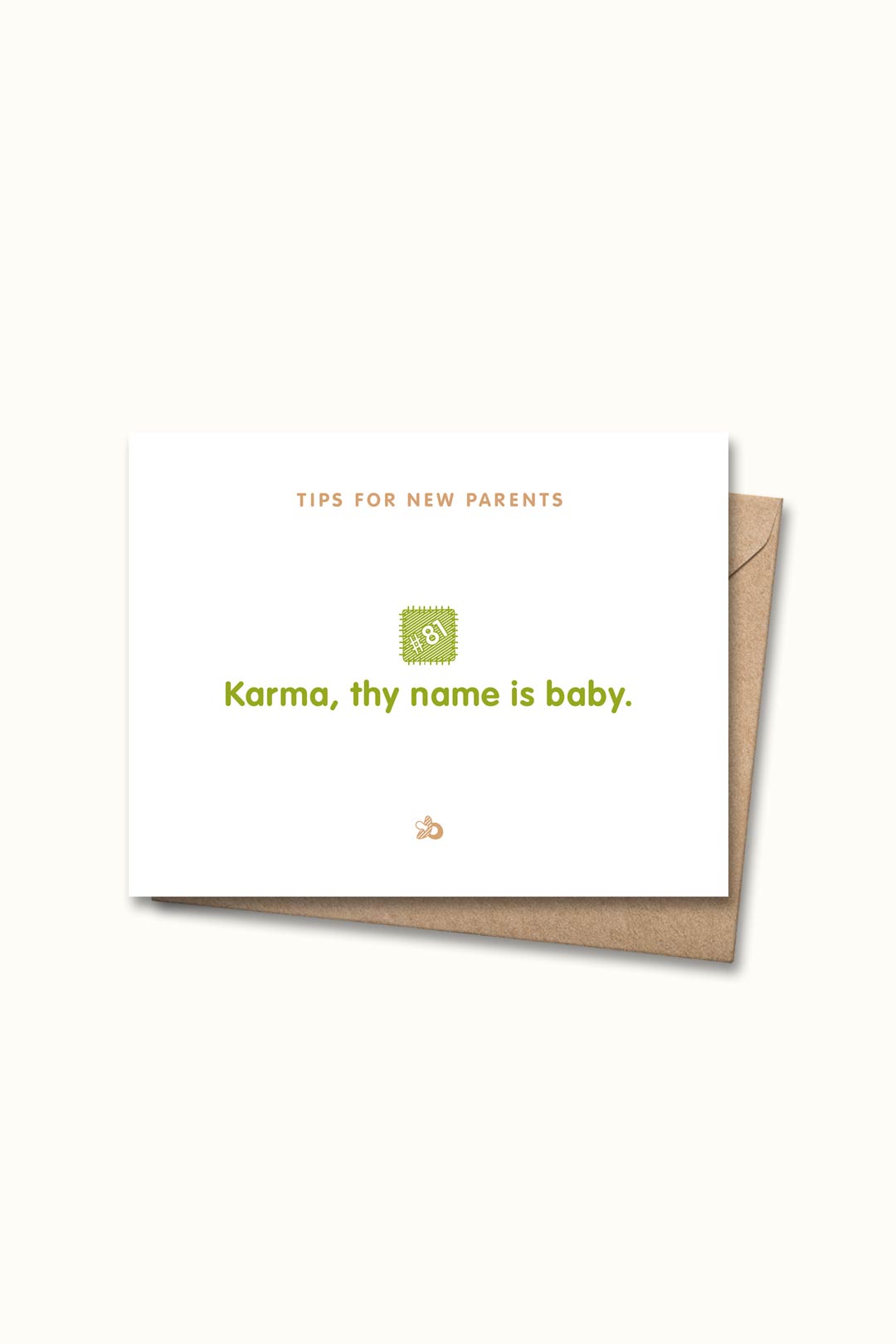 Letterpressed greeting card with wooden block and paw prints illustrations, the words "tips for new parents: karma, thy name is baby" on white background, and taupe envelope