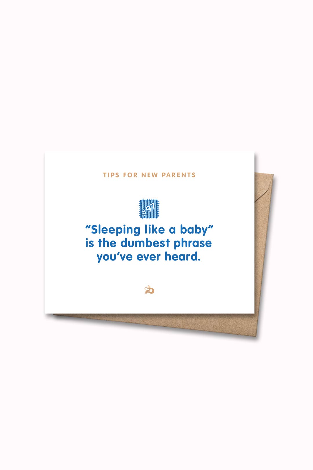 Letterpressed greeting card with wooden block and paw prints illustrations, the words "tips for new parents: "sleeping like a baby" is the dumbest phrase you've ever heard" on white background, and taupe envelope