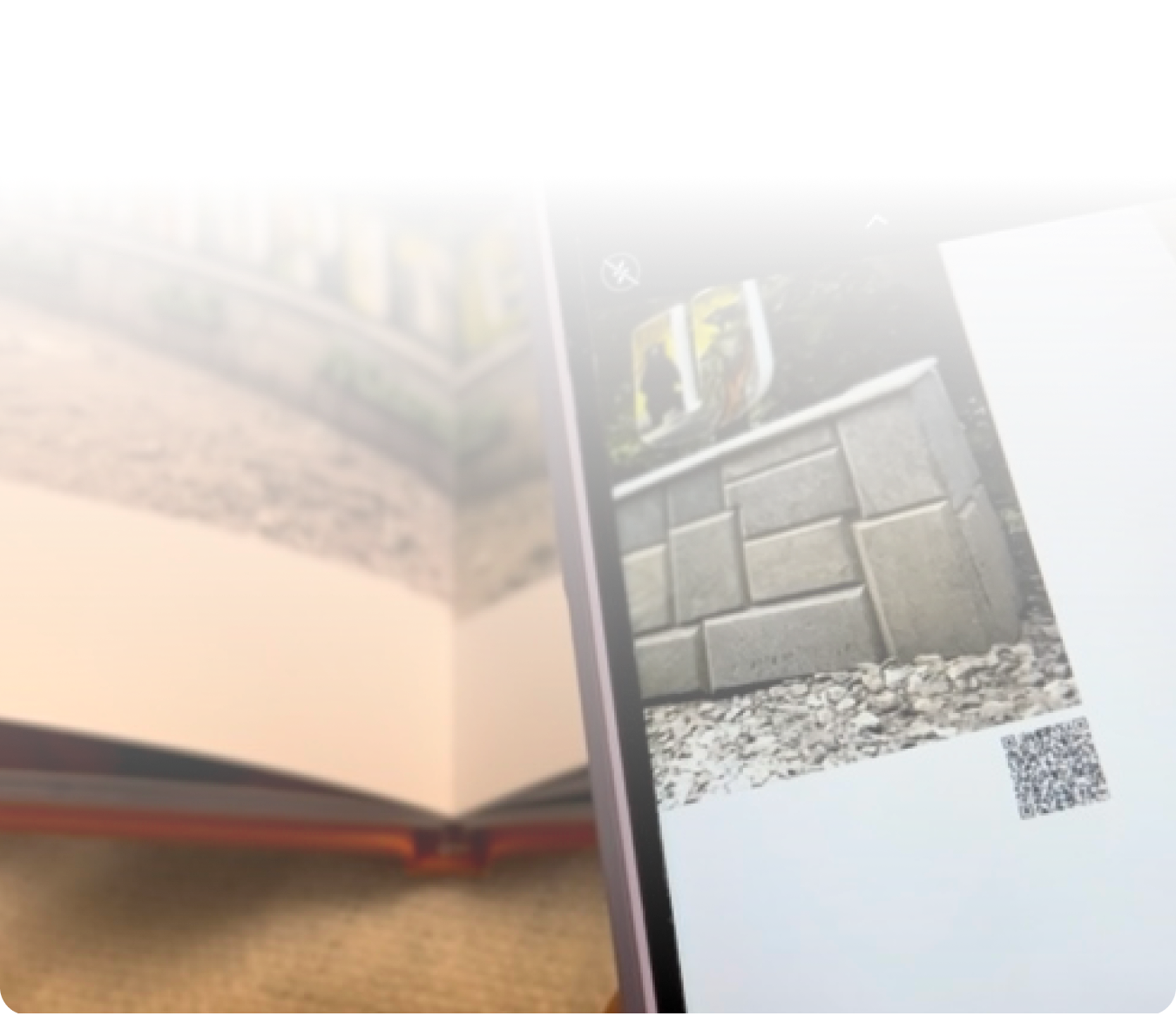 Smartphone displaying an augmented reality view of a concrete block structure on a printed page with a QR code.
