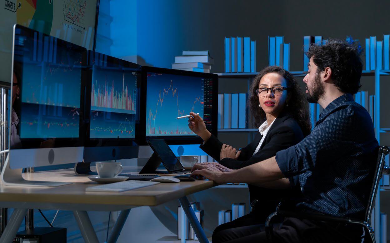 Two data analysts working in the office late into the night.