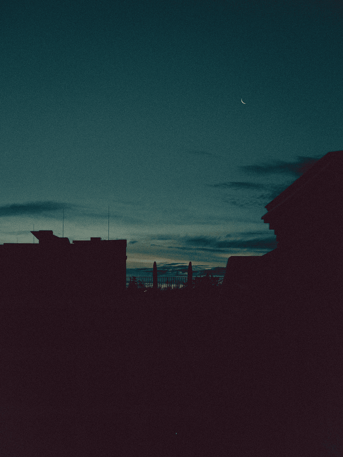 Crescent moon seen from a roof top at sunrise