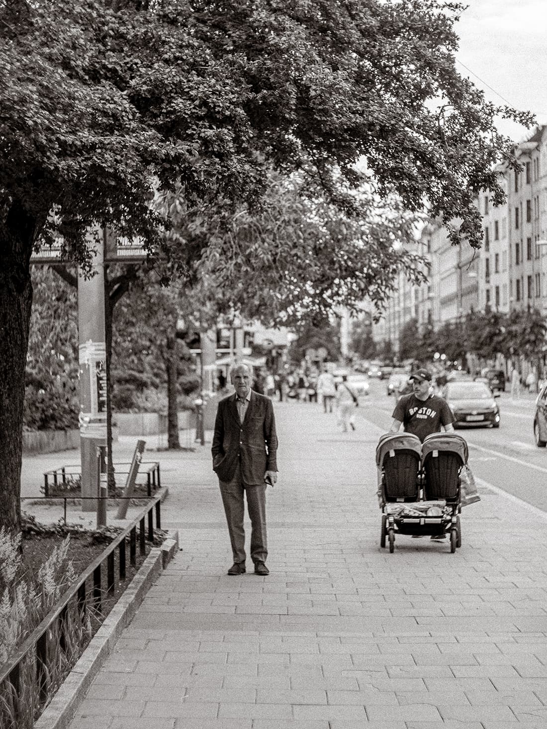 Portrait of man in the street, passed by man with a stroller