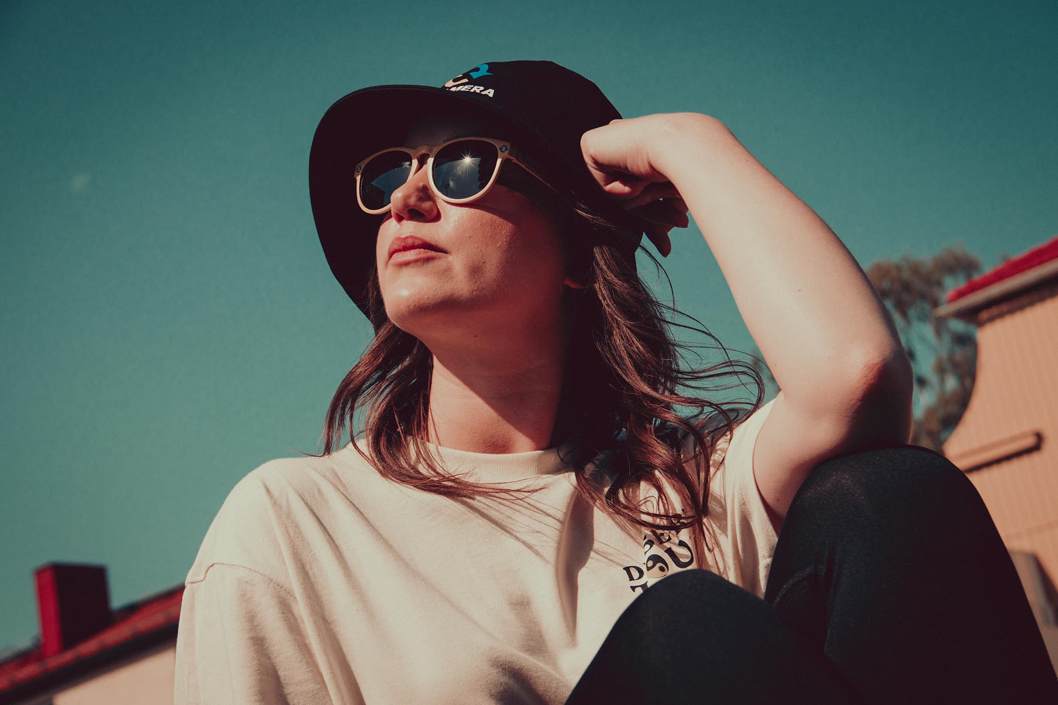 Woman in sunglasses and bucket hat sitting in the sun