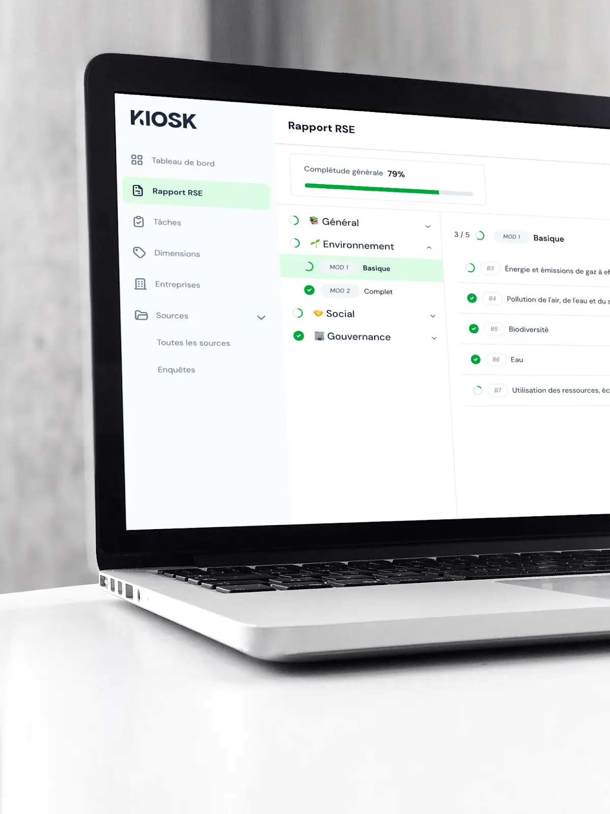 Ordinateur portable affichant un tableau de bord d'application avec un rapport RSE à 79% de complétude, incluant des sections Général, Environnement, Social, et Gouvernance.