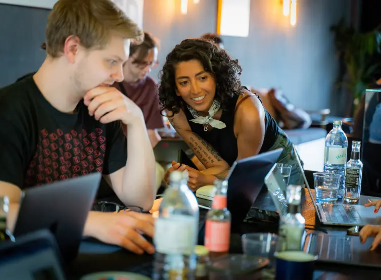 Two colleagues at Berlin Bytes exchange their ideas on the laptop