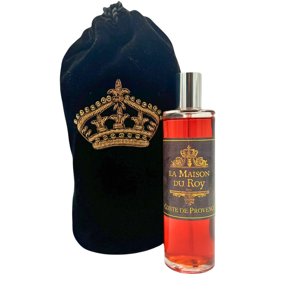 Flacon de parfum avec étiquette La Maison du Roy et un sac noir brodé d'une couronne dorée.