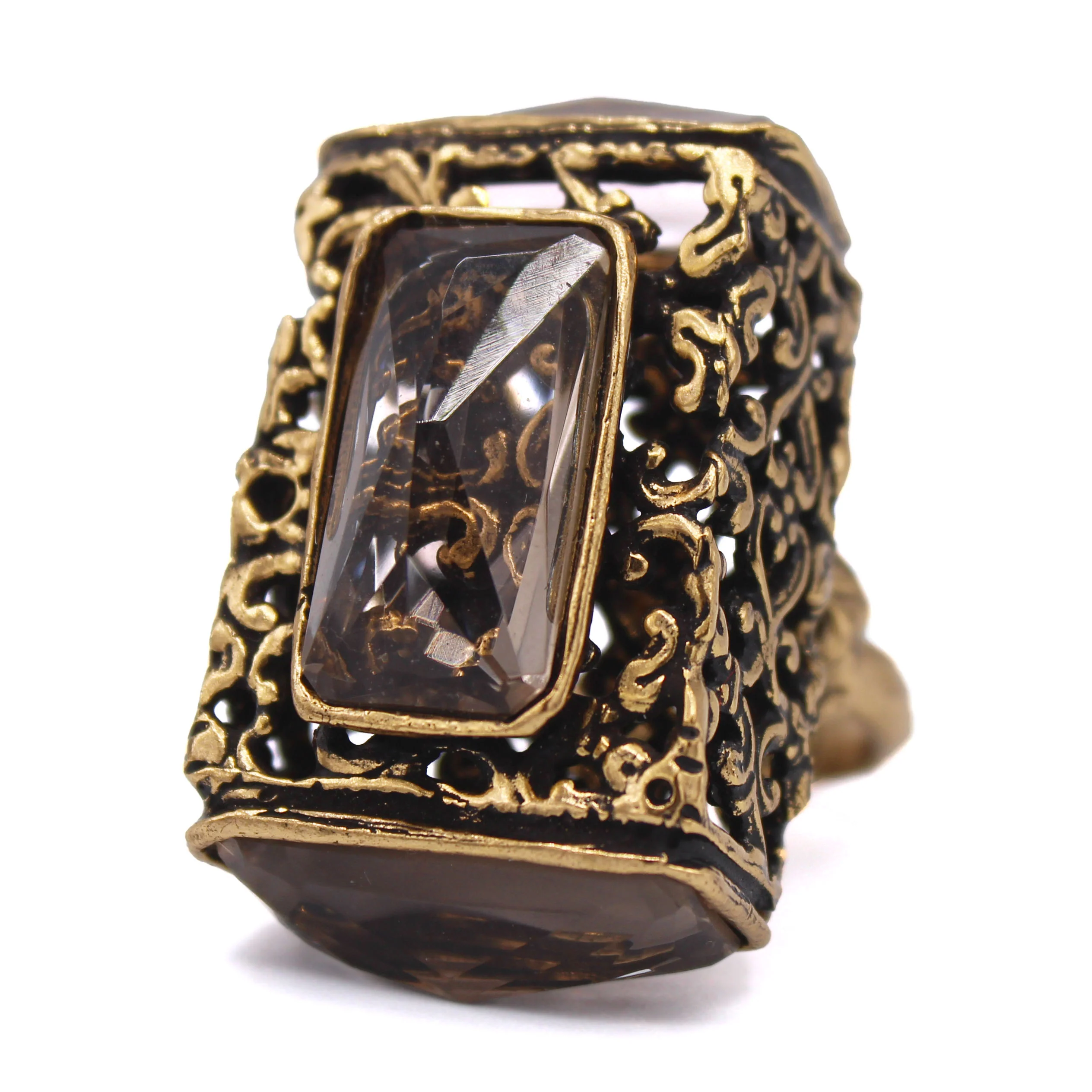 Bague vintage en métal doré avec un grand cristal rectangulaire et une monture décorative.