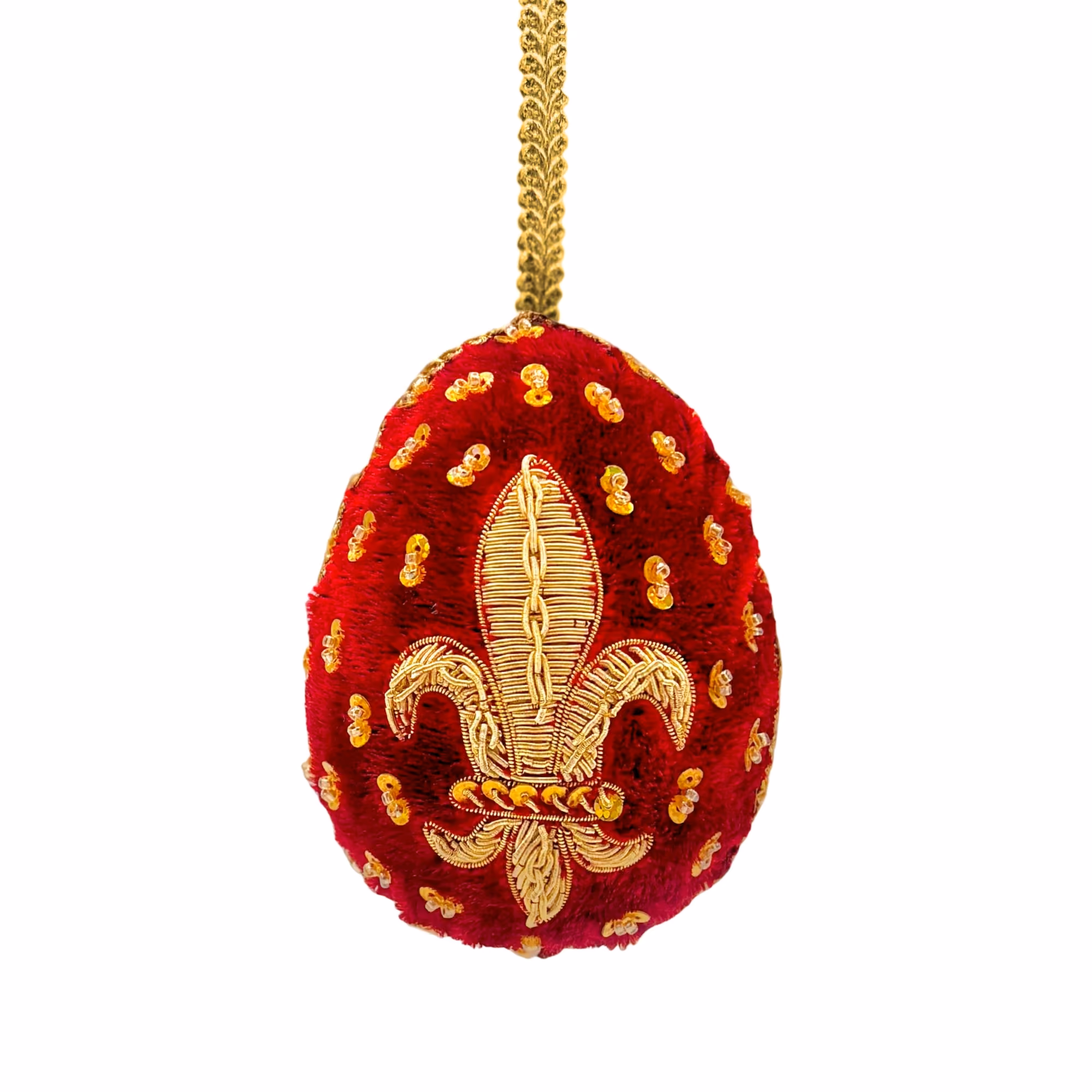 Œuf rouge orné d’une fleur de lys dorée brodée avec des sequins, suspendu par une chaîne dorée.
