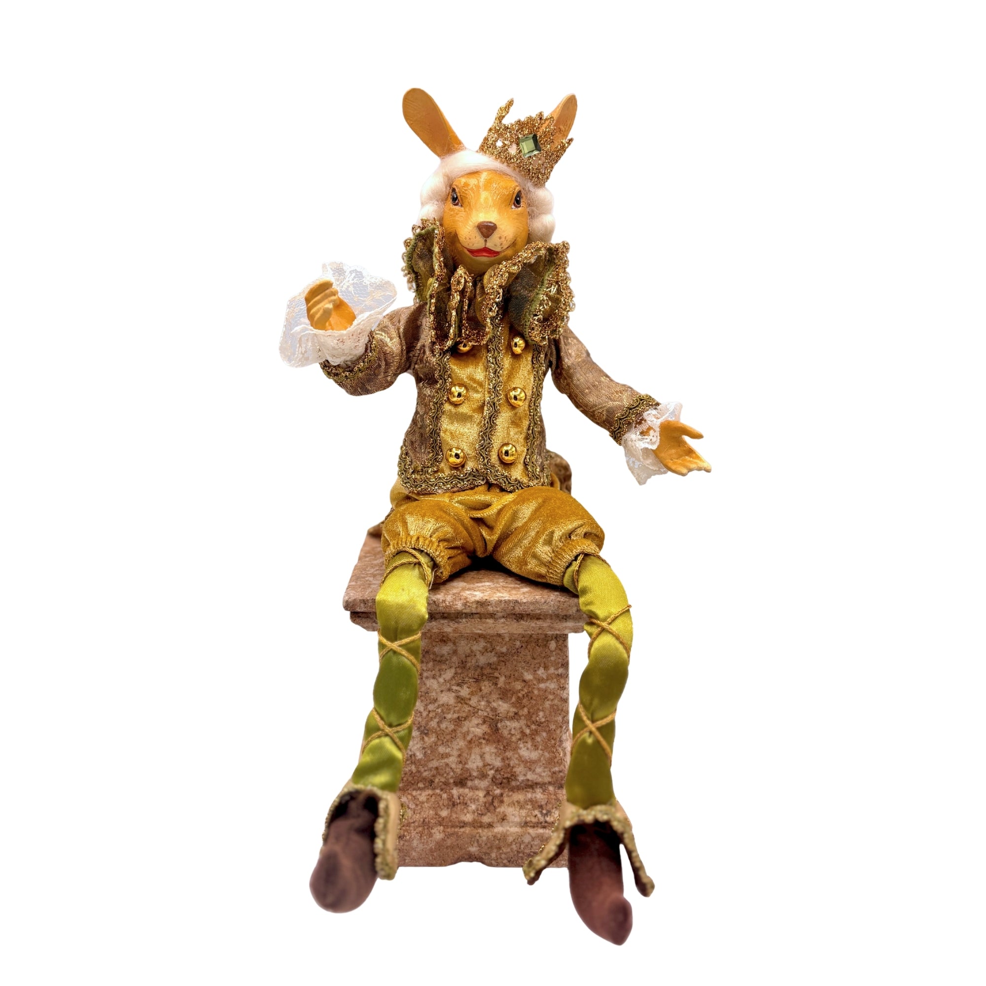 Figurine lapin en costume vert et doré avec couronne, assis sur un socle, jambes pendantes et détails brodés