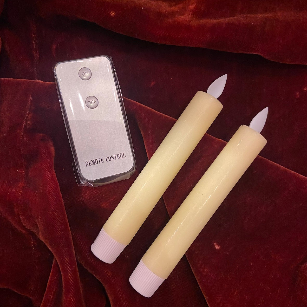 Coffret de deux bougies ivoire à piles avec télécommande sur velours bordeaux