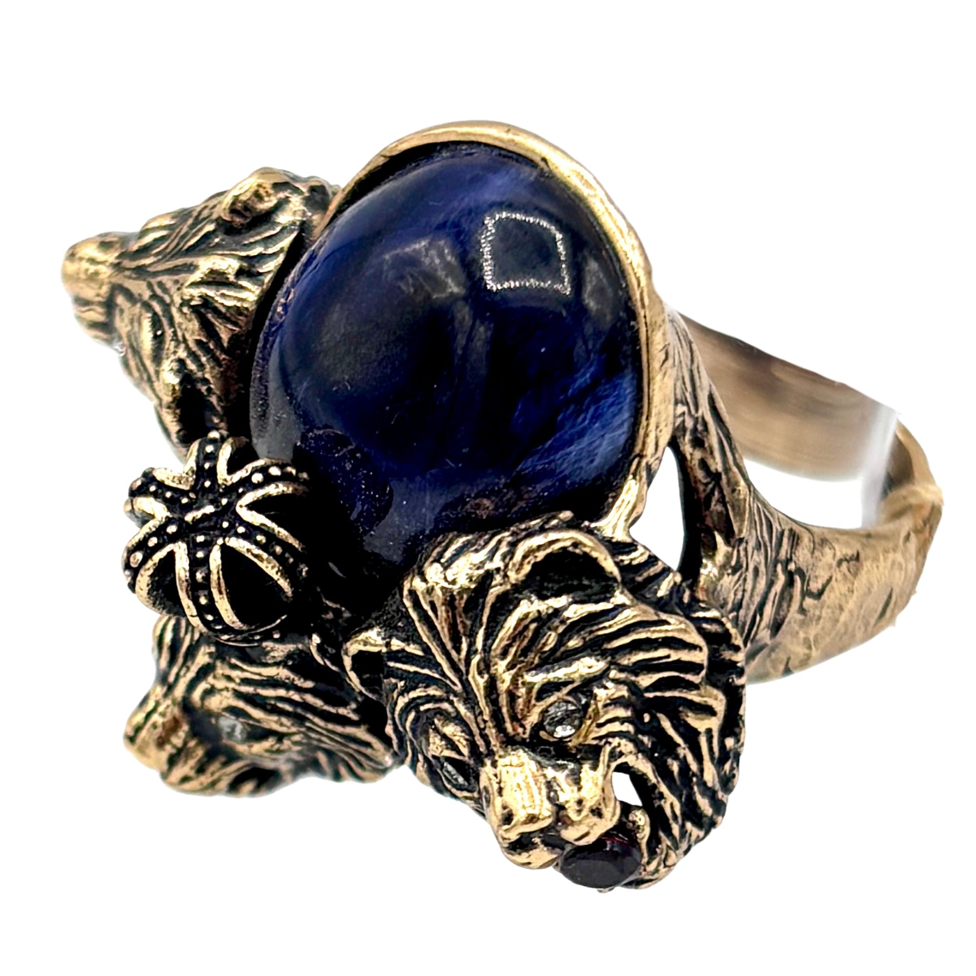 Bague dorée ornée d’un saphir ovale bleu foncé, tête de lion sculptée et grenat rouge, détails Swarovski décoratifs