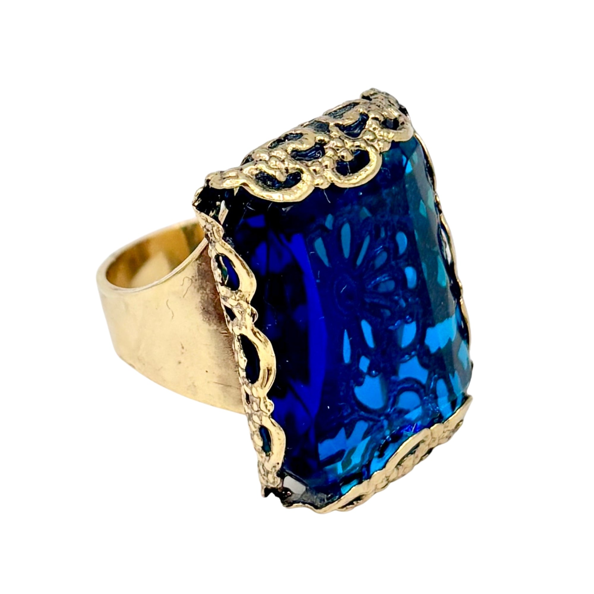 Bague en métal doré avec grand cristal rectangulaire bleu marine et monture ajourée ornée