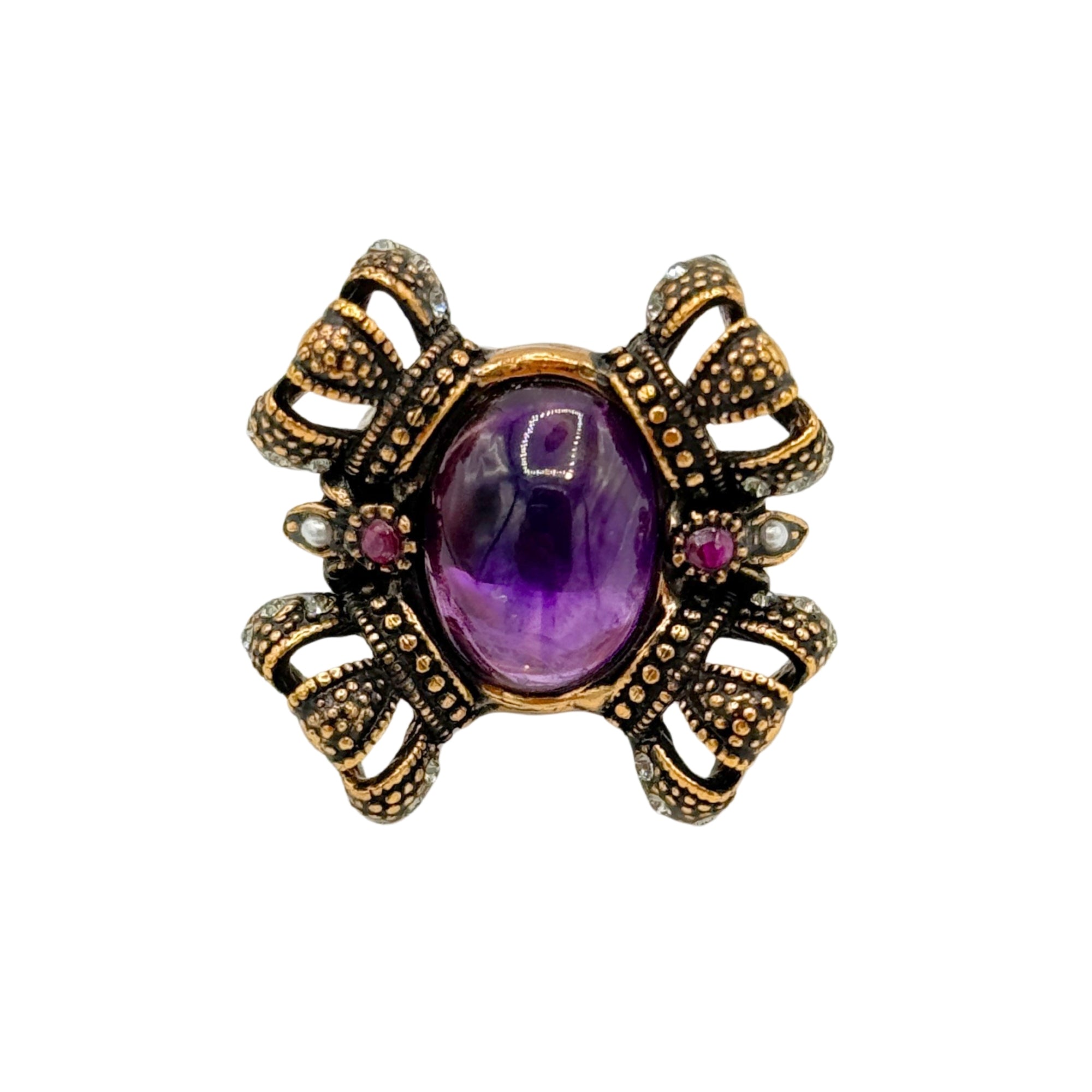 Bague en laiton avec améthyste ovale centrale, décor ajouré, détails en relief et petites pierres rouges