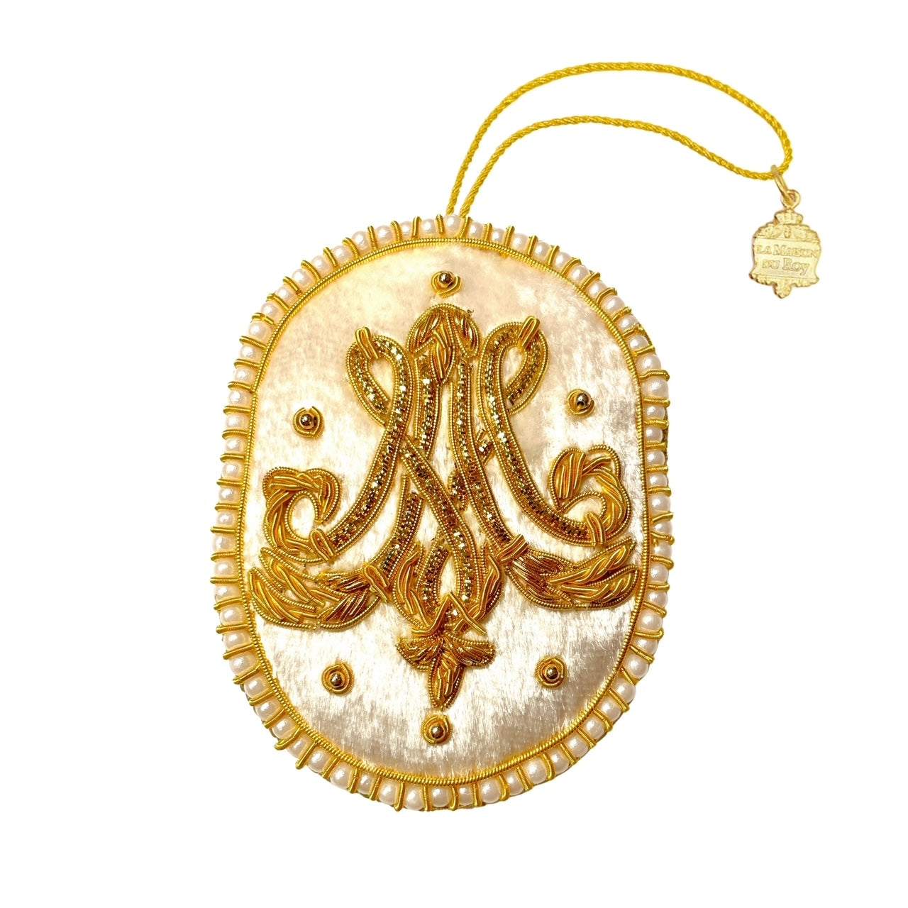 Broderie ovale en velours écru avec monogramme MA doré et bordure de perles